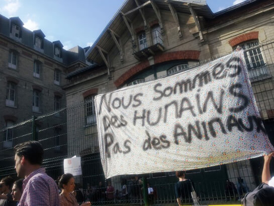 //Migrants send a message – “We are humans, not animals”. Credit: Amnesty International France