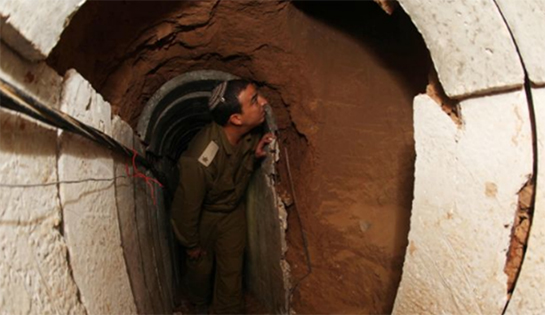 //An Israeli soldier patrols inside the tunnel dug by Hamas.