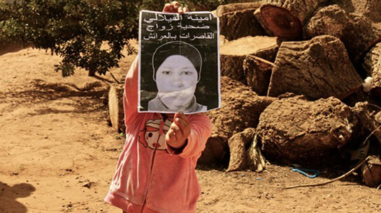 //La petite soeur d'Amina Filali portant la photographie de sa soeur © Riley Dufurrena