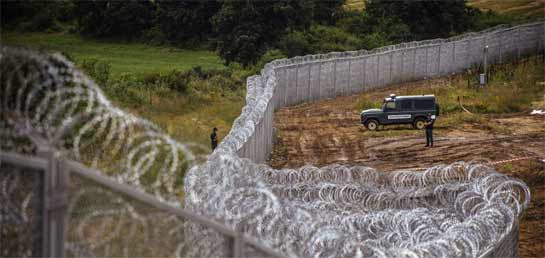 //17 juillet 2014. Une patrouille de police face au mur de barbelés de 30km de long et de 3m de haut, dressé par la Bulgarie sur la frontière avec la Turquie, non loin du village de Golyam Dervent. Plus de 10 000 réfugiés avaient traversé cette frontière en 2013, la plupart venant de Syrie. DIMITAR DILKOFFDIMITAR DILKOFF/AFP/GETTY IMAGES