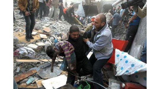 //Un Palestinien transporte le corps d'un enfant tué dans un bombardement de l'aviation israélienne sur Gaza, le 18 novembre. (Photo Mahmud Hams. AFP)