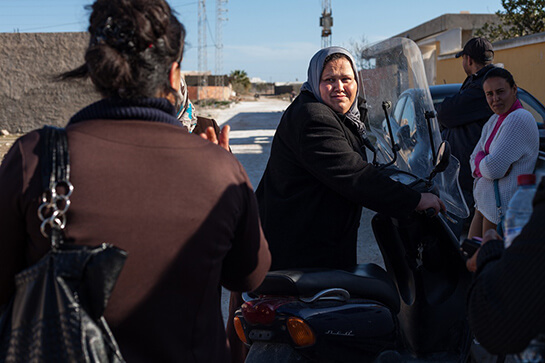 //Houda Charfeddine a trois enfants dont un fils de 9 mois. Son mari est pêcheur et elle espère préserver leurs deux sources de revenus modestes pour pouvoir faire “vivre convenablement” leurs enfants. Quand elle travaille ou milite pour ses droits, Houdaconfie son bébé à sa voisine. Crédit image: Monia Ben Hamadi.