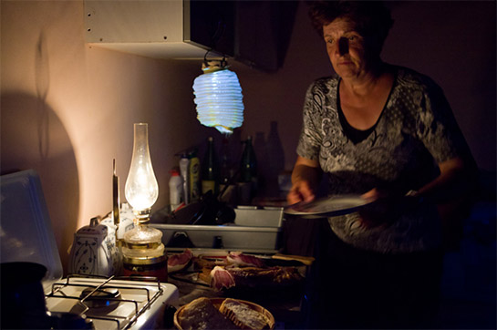 //Lonačari. Nella sua cucina, la signora Lončar prepara la cena a lume di lampada. Prima della guerra c’era la corrente elettrica.