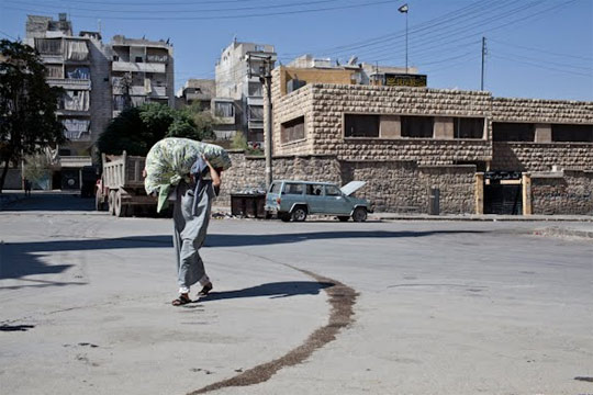 //Un uomo uscito dalla base degli Ahrar El Sham va a bruciare i vestiti dei condannati a morte (foto di Alessio Genovese)