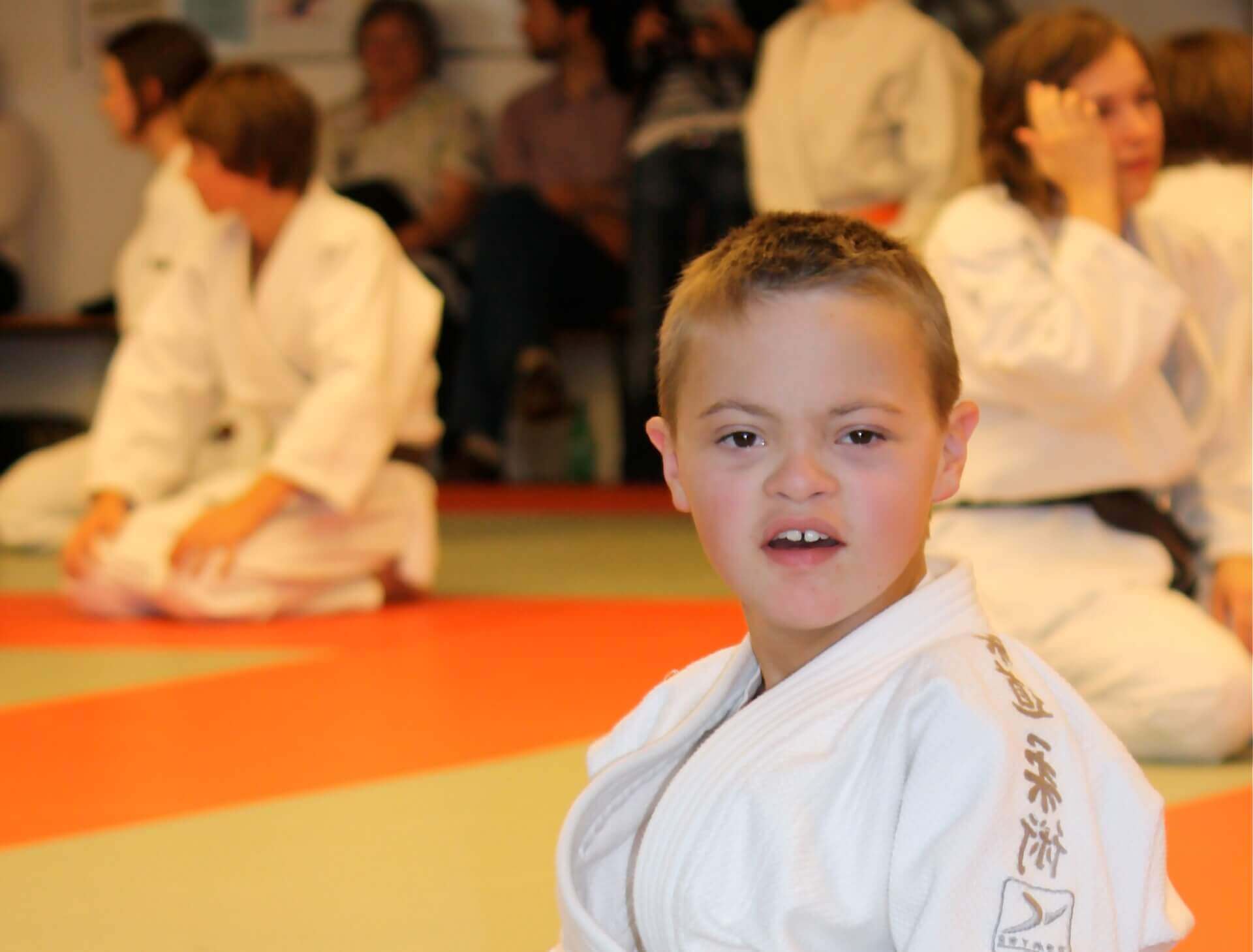 un garçon avec trisomie  21 en kimono sur un tatami | Trisomie 21 Nouvelle Aquitaine